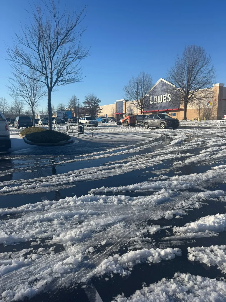 Fonvilletreeservice documents slushy melting snow covering commercial retail parking lot with vehicle tracks visible in NC winter conditions