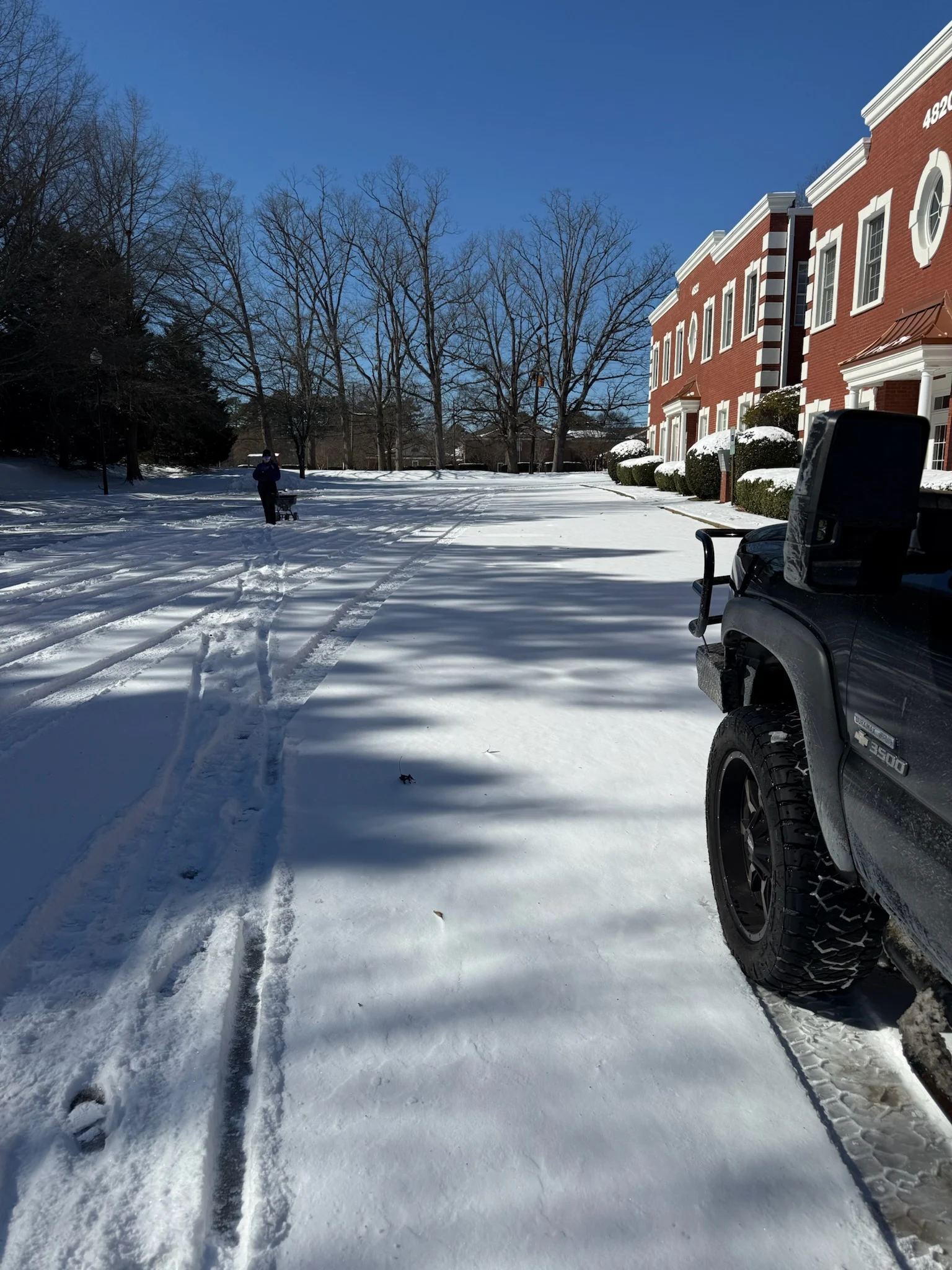 Fonvilletreeservice crew member operating snow removal equipment to clear commercial parking lot after winter storm in NC