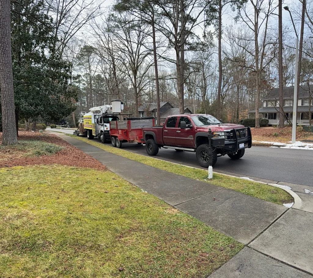 Fonvilletreeservice crew trucks and utility trailer with bucket truck parked on residential street ready for tree service in Wake County NC