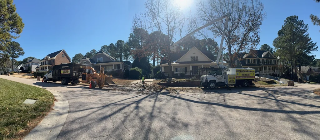 Fonvilletreeservice crew operating bucket truck and wood chipper during residential lot clearing with fallen branches in NC neighborhood